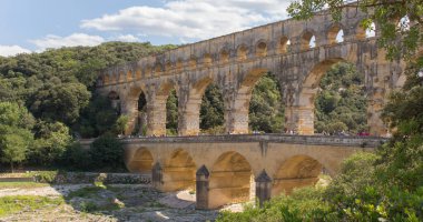 Pont du Gard, Gardon nehri üzerinde Provence 'de (Fransa) inşa edilmiş üç katlı bir Roma su kemeridir. Avrupa'nın en yüksek Roma köprüsünün bu görünümü güneşli bir yaz günü alınır. - Resim