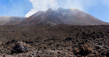 Etna Dağı'nın lav siyahkayalarının yakın çekim. Sicilya, İtalya'da volkan kraterleri ile Manzara. Ünlü Sicilya yanardağı arka planda sigara içiyor. - Resim