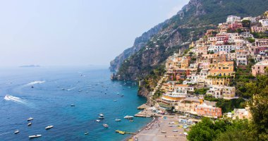 İtalya'da (Campania) Amalfi Sahili'ndeki Positano köyünün panoraması. Mavi gökyüzü ve pastoral deniz, plaj ve renkli evler ile güneşli bir yaz günü. - Resim