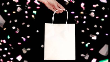 Siyah arka plan üzerine izole boş beyaz kağıt torba tutarak el