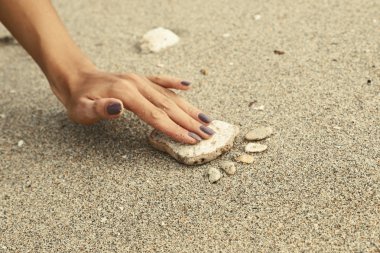 Bir genç kızın el ayak izi büyük çakıl kum yayılmış