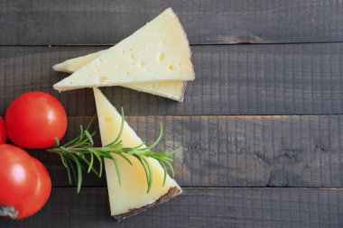 Spanish manchego cheese sliced on a wooden background  clipart