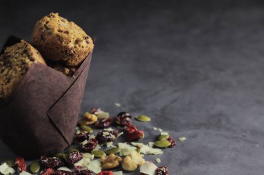 Fındık, tohum, kuru kızılcık, kabak çekirdeği, ceviz, chia tohumu, goji çilek, hindistan cevizi ile zanaat kağıt Enerji çerezleri - koyu arka plan vegan vejetaryen çiğ organik atıştırmalık, kopya alanı. Superfood