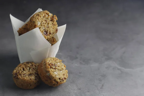 Fındık, tohum, kuru kızılcık, kabak çekirdeği, ceviz, chia tohumu, goji çilek, hindistan cevizi ile zanaat kağıt Enerji çerezleri - koyu arka plan vegan vejetaryen çiğ organik atıştırmalık, kopya alanı. Superfood
