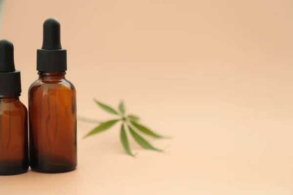Tam ile koyu cam şişeler, cannabidiol yağı ve kenevir bir pastel arka plan üzerinde yaprakları. Sağlık anlayışı. Tıbbi marihuana. Kopyalama alanı