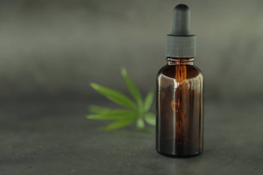 Tam ile koyu cam şişeler, kannabidiol yağı ve kenevir koyu bir arka plan üzerinde yaprakları. Sağlık anlayışı. Tıbbi marihuana.