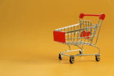 sarı arka plan üzerinde izole mini boş alışveriş sepeti 