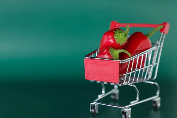 Mini Nákupní Vozík Červenými Teplými Papričkami Zeleném Pozadí Chilli Papriček — Stock fotografie