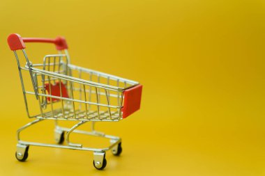 sarı arka plan üzerinde izole mini boş alışveriş sepeti 