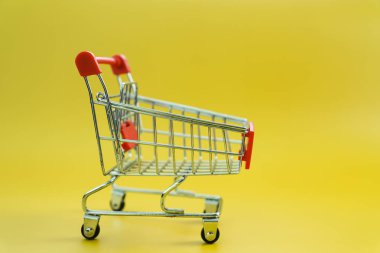 sarı arka plan üzerinde izole mini boş alışveriş sepeti 