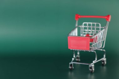 yeşil arka plan üzerinde izole mini boş alışveriş sepeti 