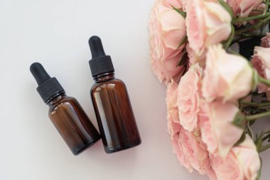 Koyu kozmetik şişeler, üzerinde pembe güller var. Kopya alanı. Dostu doğal kozmetik konsepti. Minimalizm. Güzellik blogger, spa salonu, terapy salon.