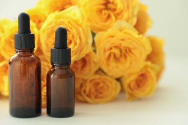 Koyu kozmetik şişeler, parlak bir arka plan üzerinde sarı güller ile. Kopya alanı. Dostu doğal kozmetik konsepti. Minimalizm. Güzellik blogger, spa salonu, terapy salon.