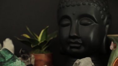 Masanın üzerinde mum olan Buda heykeli.