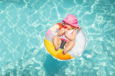 Float Carribean mavi su üzerinde güzel güneşli günde uyuyan sevimli bebek kız