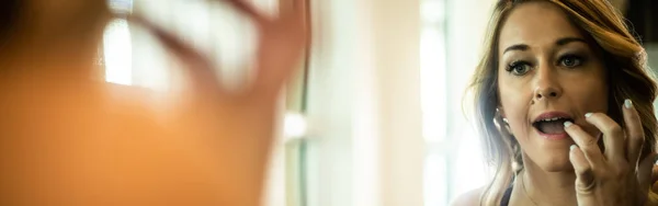 Seksi kadın onun güzel banyo aynaya rujla uygulama