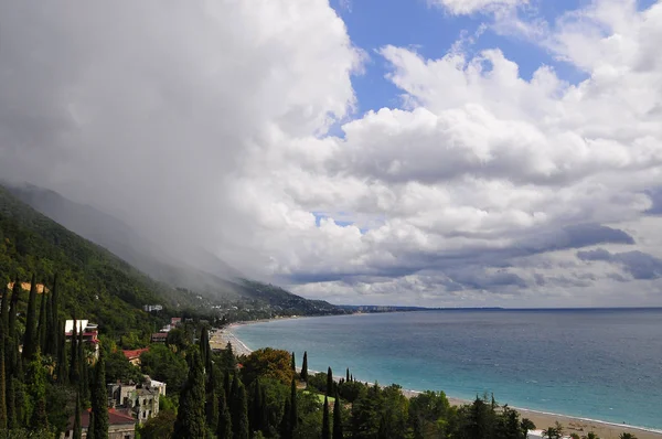 rain in the mountains on a sunny afternoon by the sea