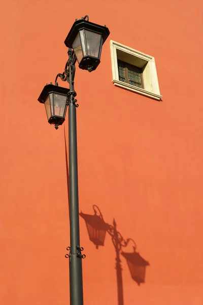 Vintage street lamp with its shadow on the wall.
