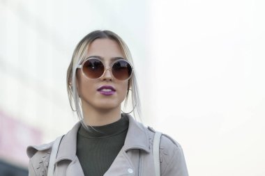 Güzel bir genç modern ve kentsel kadın dışında güneş gözlüğü ile portresi