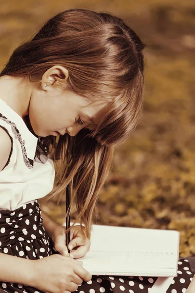 Pequena Menina Bonito Desenha Escreve Seu Caderno Ela Muito Inspirada — Fotografia de Stock