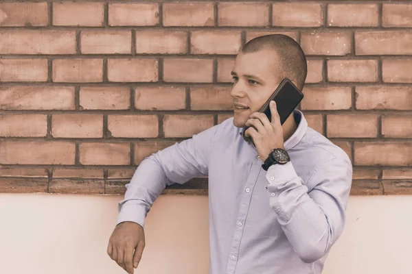 Yakışıklı genç bir eski bina önünde duruyor ve bir cep telefonu üzerinde görüşmeler. 