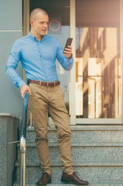 Binanın önünde duran ve bir cep telefonu tutan genç yakışıklı bir işadamı. O işten eve gider ve bir cep telefonu yeni iletileri okumak için kullanır. Manifatura mesaj