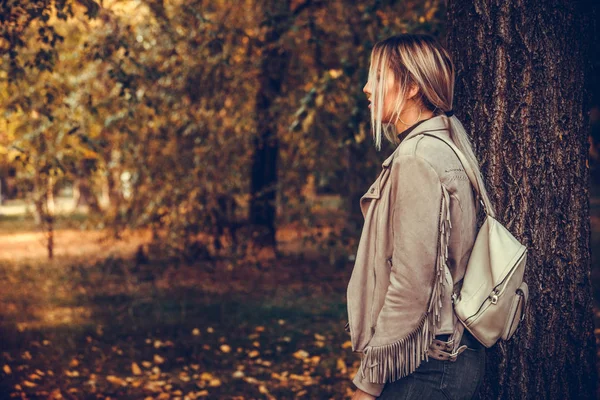 Young woman with a backpack on his back walking through the park