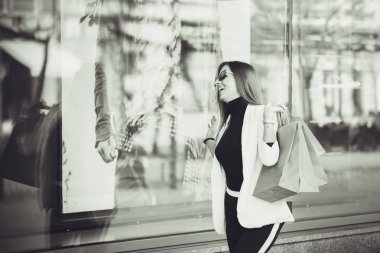 Alışveriş torbaları bol açık havada güzel genç kadın. Sürpriz ile moda giysiler içinde genç Alışverişkoliğin kadın portre yüz o gördüğünüz gibi pencere siyah ve beyaz fotoğraf alışveriş, newc giyim