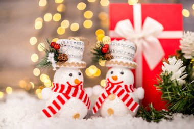 Kardan adam, kar ve ışıklar içinde belgili tanımlık geçmiş ahşap bir zemin üzerine Noel dekorasyonu. Yeni Yılınız Kutlu Olsun. Kopya alanı