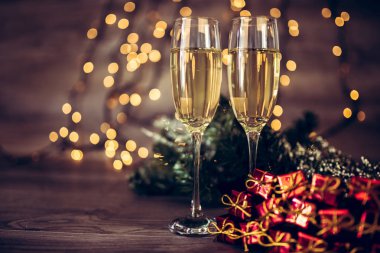 İki kadeh şampanya ve ahşap arka plan, Happy New Year ışıkları ile Noel dekorasyonu. Kutlama. Seçici odak ve küçük alan derinliği.
