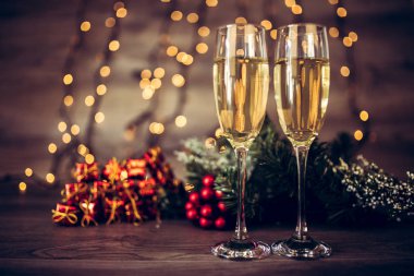 İki kadeh şampanya ve ahşap arka plan, Happy New Year ışıkları ile Noel dekorasyonu. Kutlama. Seçici odak ve küçük alan derinliği.