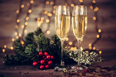 İki kadeh şampanya ve ahşap arka plan, Happy New Year ışıkları ile Noel dekorasyonu. Kutlama. Seçici odak ve küçük alan derinliği.