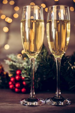 İki kadeh şampanya ve ahşap arka plan, Happy New Year ışıkları ile Noel dekorasyonu. Kutlama. Seçici odak ve küçük alan derinliği.