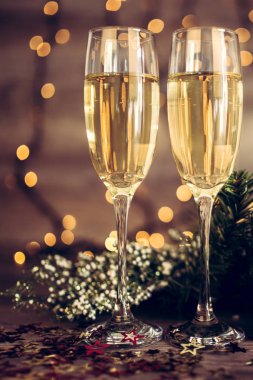 İki kadeh şampanya ve ahşap arka plan, Happy New Year ışıkları ile Noel dekorasyonu. Kutlama. Seçici odak ve küçük alan derinliği.