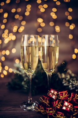 İki kadeh şampanya ve ahşap arka plan, Happy New Year ışıkları ile Noel dekorasyonu. Kutlama