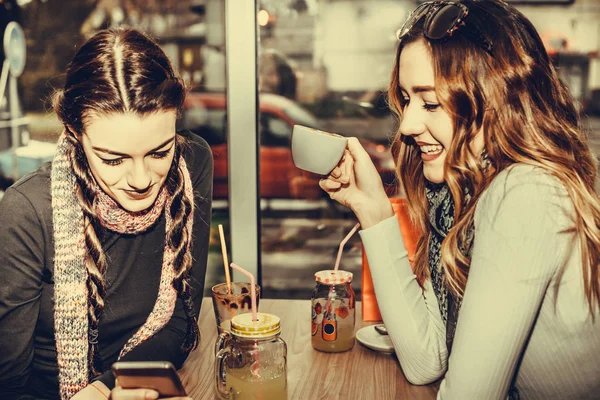 Две Симпатичные Девушки Используют Смартфон Пьют Кофе Кафе — стоковое фото