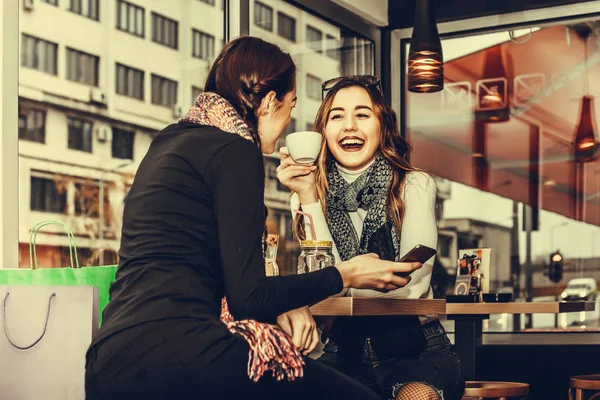 Две Симпатичные Улыбающиеся Девушки Используют Смартфон Пьют Кофе Кафе После — стоковое фото