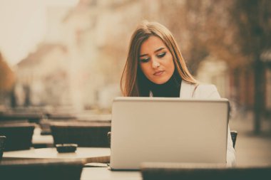 Mutlu girişimci bir kafede sokakta bir dizüstü bilgisayar ile çalışma