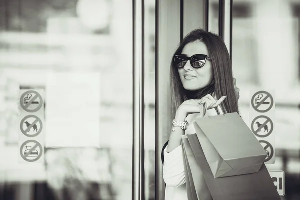 Piękny Szczęśliwy Dziewczyna Okulary Trzyma Torby Zakupy Patrząc Kamery Uśmiechając — Zdjęcie stockowe