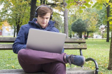 Park, seçici odak ve küçük derinlik-in tarla, içinde laptop ile genç adam lens flare