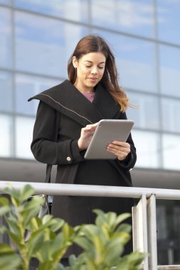 Bir tablet elinde tutan genç iş kadını, seçici odak ve küçük alan derinliği 