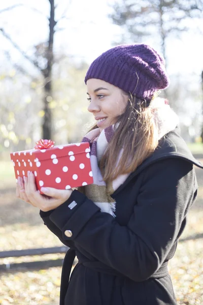 Beautiful young woman with a gift in hand, Selective focus and small depth of field, Lens flare