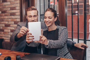 Güzel genç iş adamları dijital tablet kullanma ve kahve brea sırasında gülümseyen selfie yapıyoruz