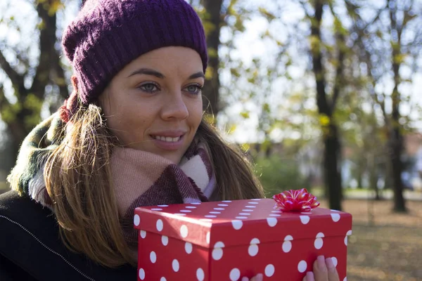 Beautiful young woman with a gift in hand