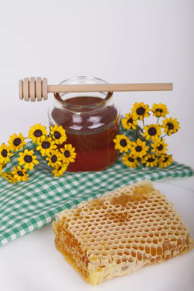 Honey in  jar with honey dipper on a light background