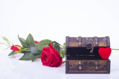 Beyaz zemin üzerine kırmızı gül ve kırmızı kalpler