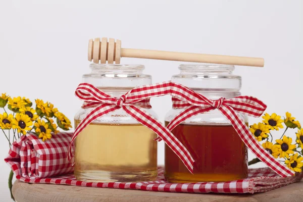 Honey in  jar with honey dipper on a light background