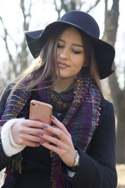 Młoda Kobieta Trzymając Telefon Ręku Zewnątrz — Zdjęcie stockowe