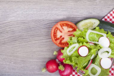 Taze marul, soğan, turp, domates ve salatalık ahşap arka plan üzerinde. Metniniz için boş alan ile. Yukarıdan görüntülemek.