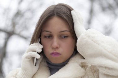 Hangi telefon görüşmeleri ve yüzünün ifadeleri gösterir bu parkta genç bir kadın portresi endişeli